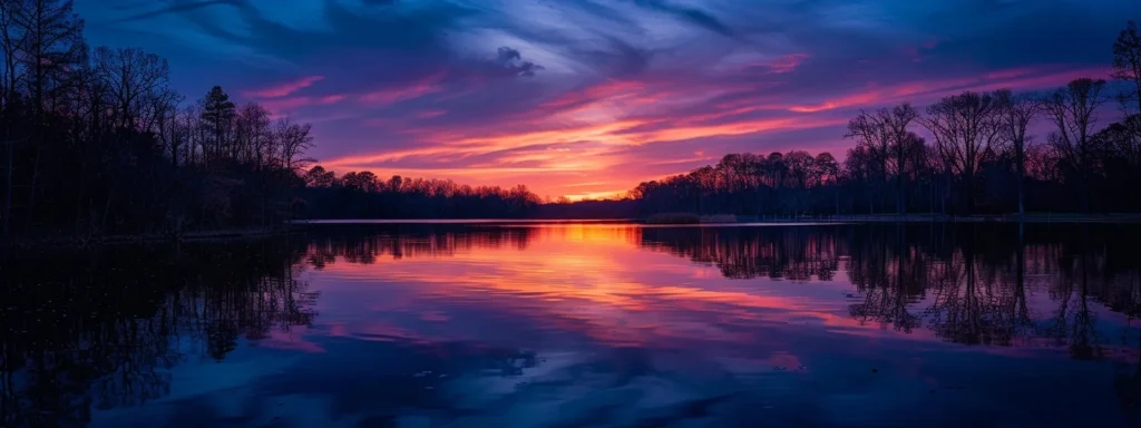 a breathtaking sunset casting vibrant hues over a tranquil lake, reflecting the fiery sky and surrounded by silhouetted trees, embodying serenity and nature's beauty.