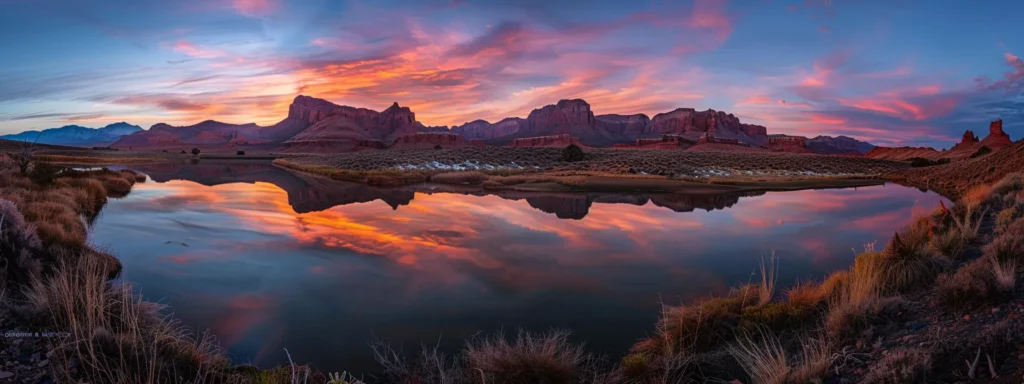 a breathtaking sunset casts vibrant hues of orange and pink across a tranquil lake, with silhouettes of majestic mountains rising in the background.