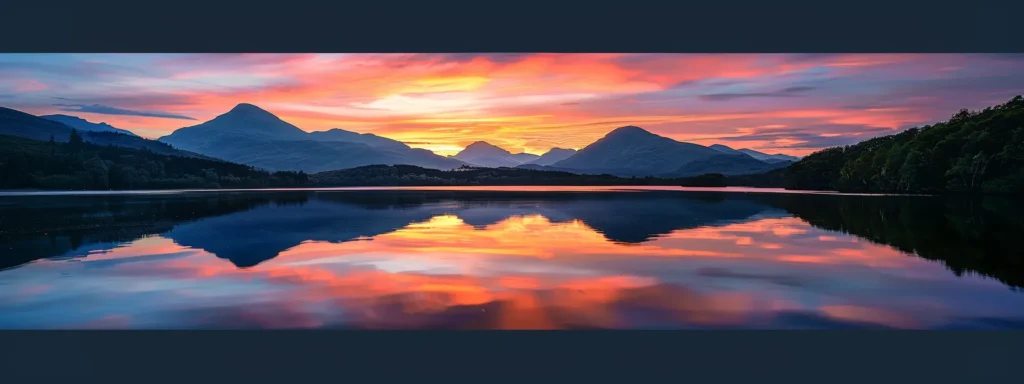 a breathtaking sunset casts vibrant hues of orange and pink over a serene lake, with silhouetted mountains reflecting perfectly in the still waters.