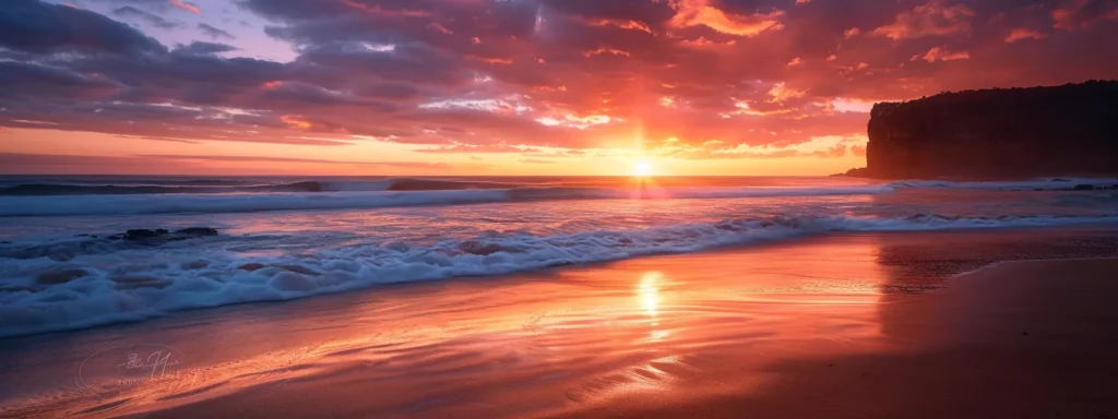 a breathtaking sunset illuminates a tranquil beach, casting vibrant hues of orange and pink across the sky, while gentle waves kiss the shore amidst a backdrop of distant cliffs.