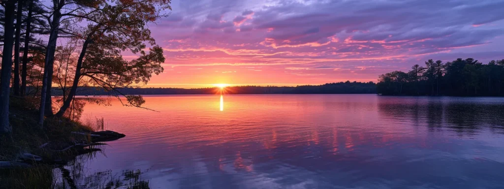 a majestic sunset casts a warm glow over a tranquil lake, reflecting vibrant hues of orange and pink in the calm water, surrounded by silhouetted trees that frame the serene horizon.