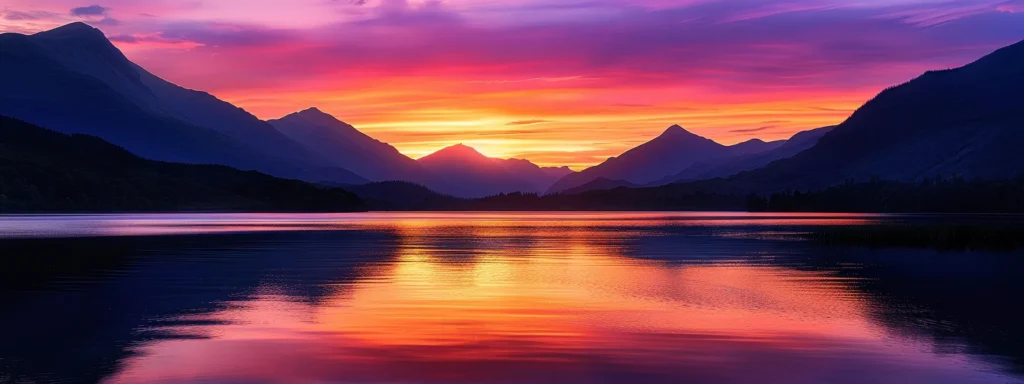 a radiant sunset casts vivid hues of orange and purple across a tranquil lake, where silhouettes of distant mountains create a dramatic backdrop, evoking a sense of peace and wonder.
