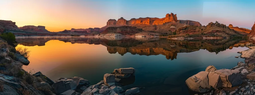 a serene sunset illuminates a tranquil lake, its vibrant hues reflecting on the glassy surface, framed by majestic mountains under a clear, fading sky.